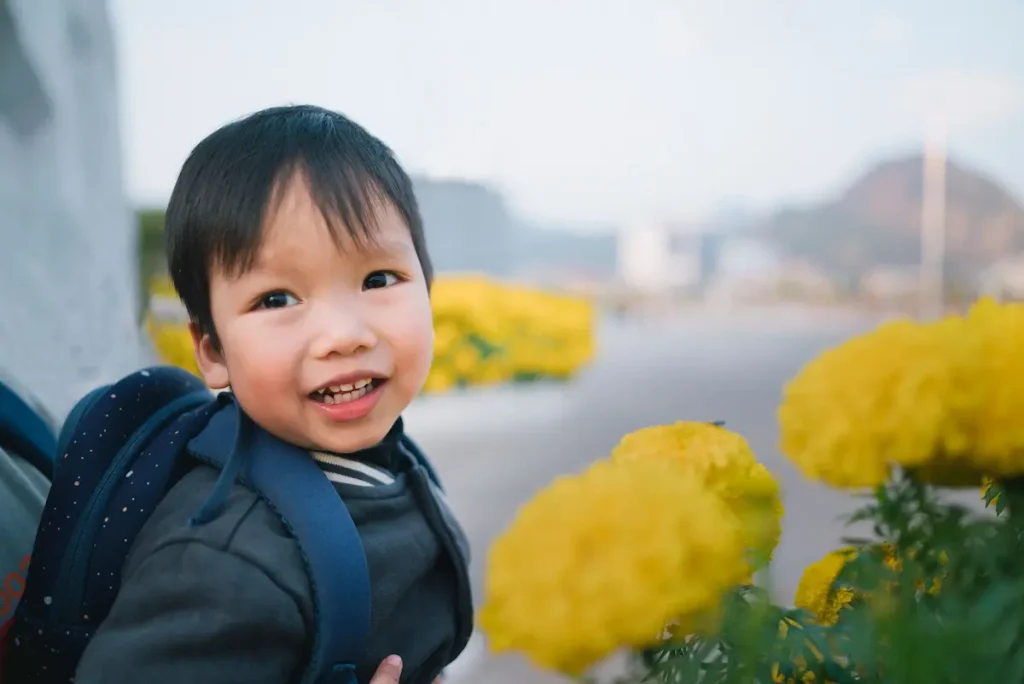 Child enjoying outdoor play at a playgroup near me surrounded by colorful flowers.