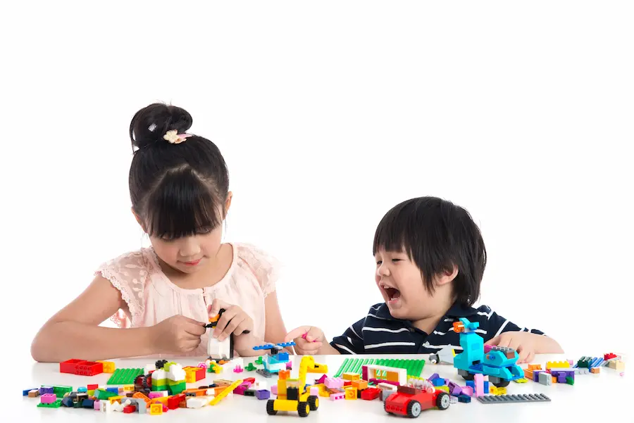 Children Playfully Building with Colorful Toy Blocks